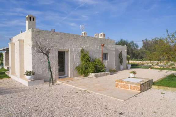 Facciata antica lamia in pietra con patio esterno e ulivi secolari